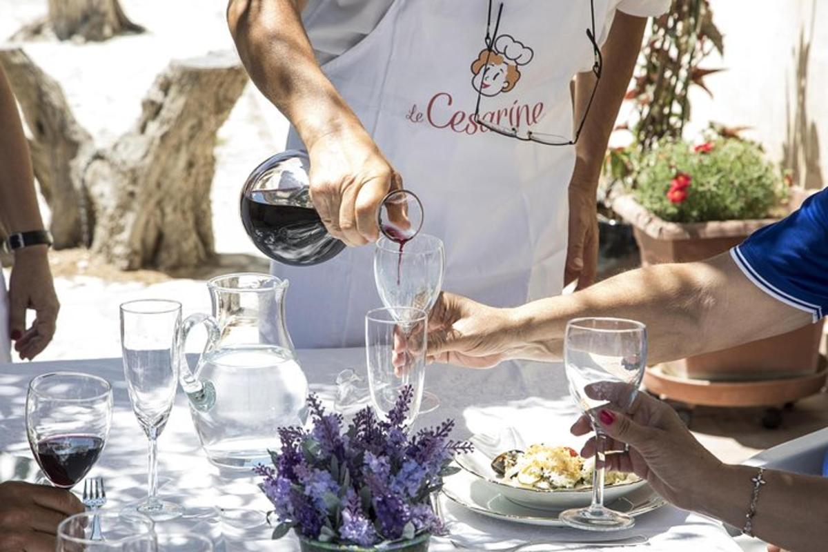 una persona che versa il vino in un bicchiere a un tavolo