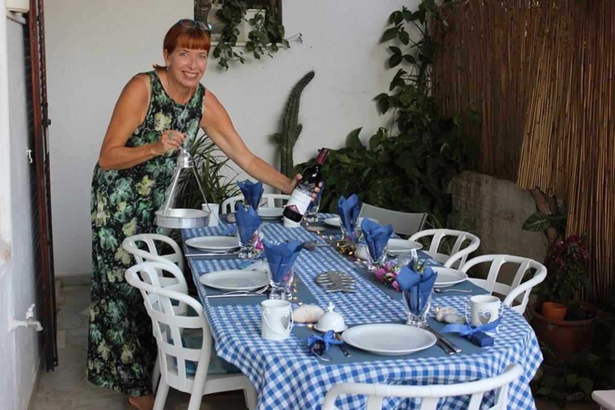 een vrouw die aan een tafel staat met een blauw en wit tafelkleed