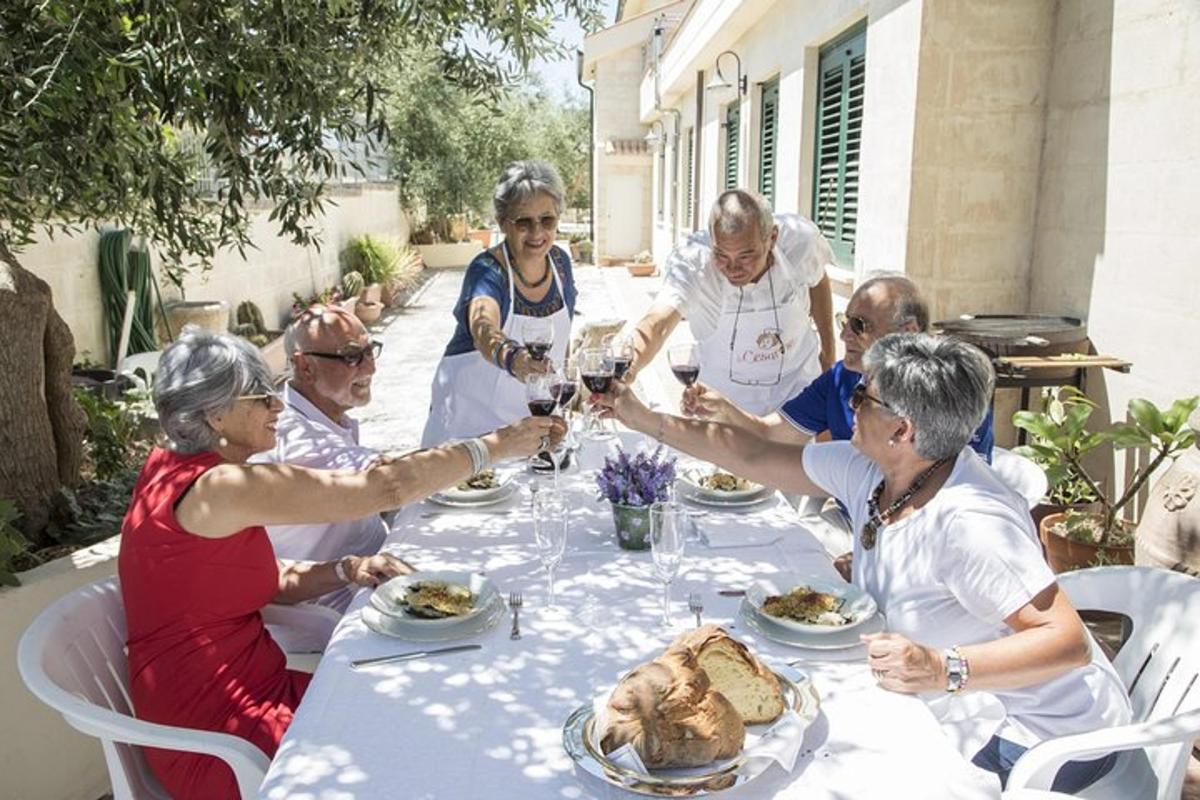 um grupo de idosos sentados ao redor de uma mesa com comida