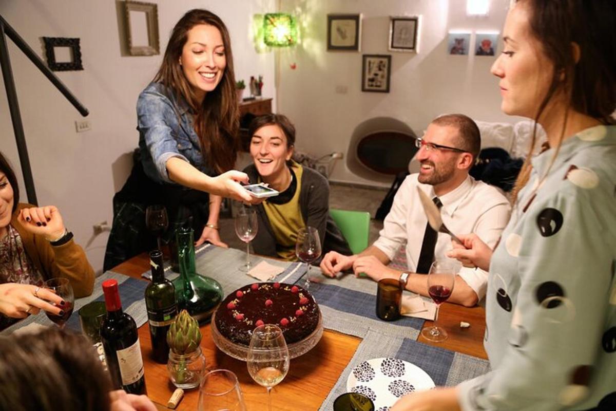 eine Gruppe von Menschen sitzt mit einem Kuchen um einen Tisch