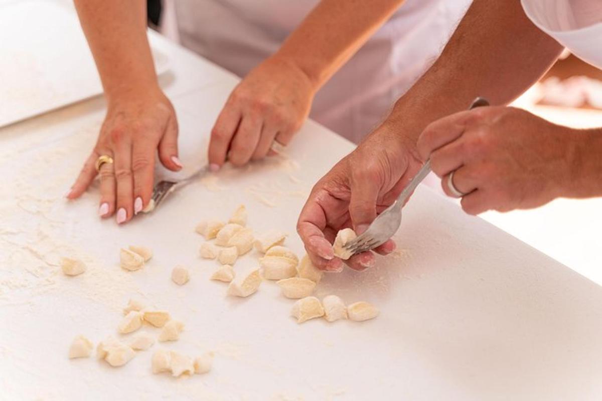 Una pareja cortando comida en una tabla de cortar.
