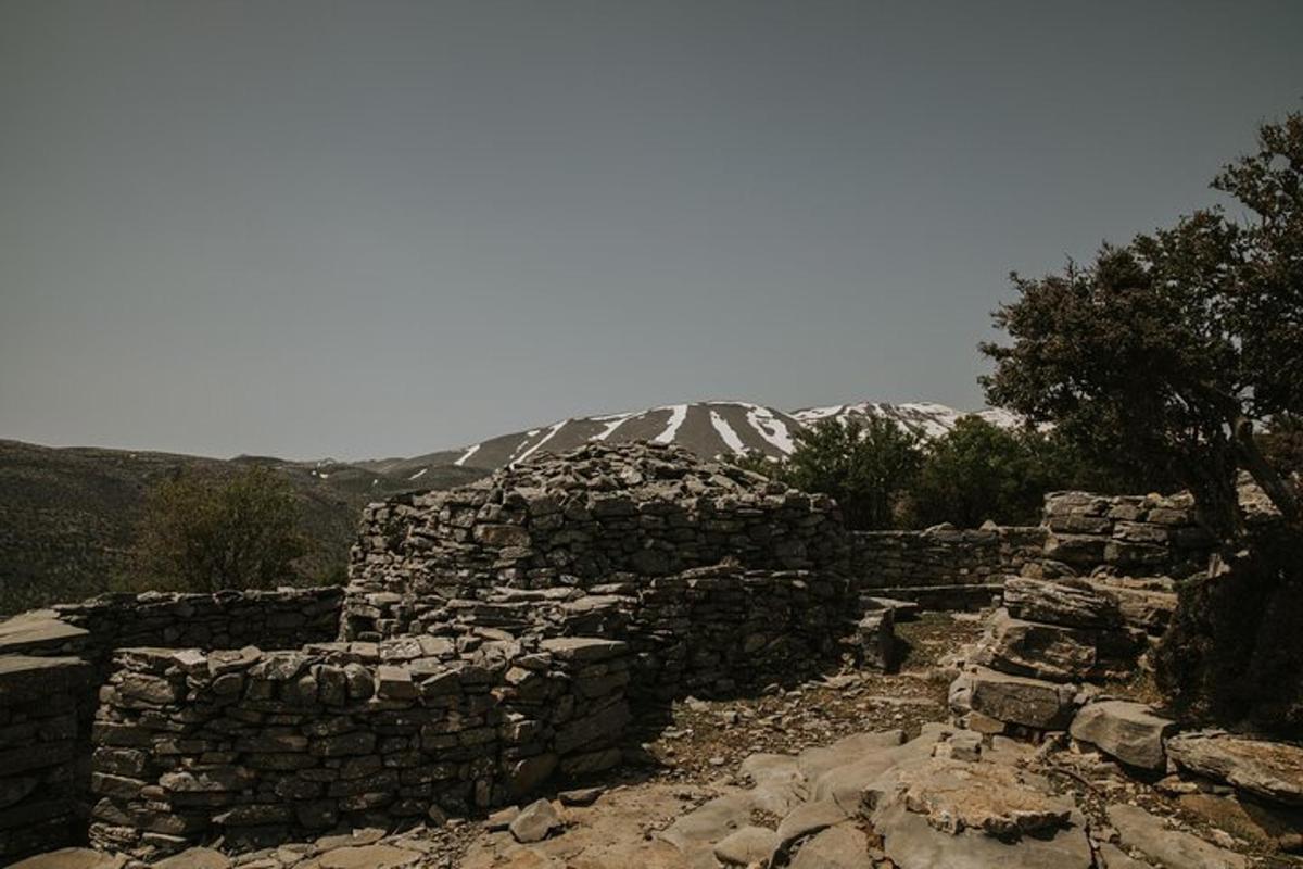 ένα παλιό πέτρινο κτίριο με ένα βουνό στο βάθος