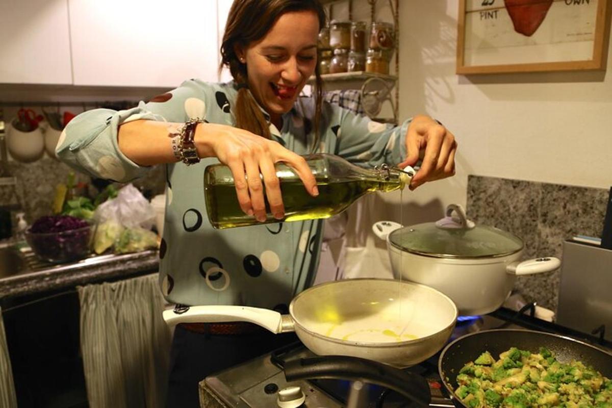 eine Frau gießt in einer Küche Wein in einen Topf