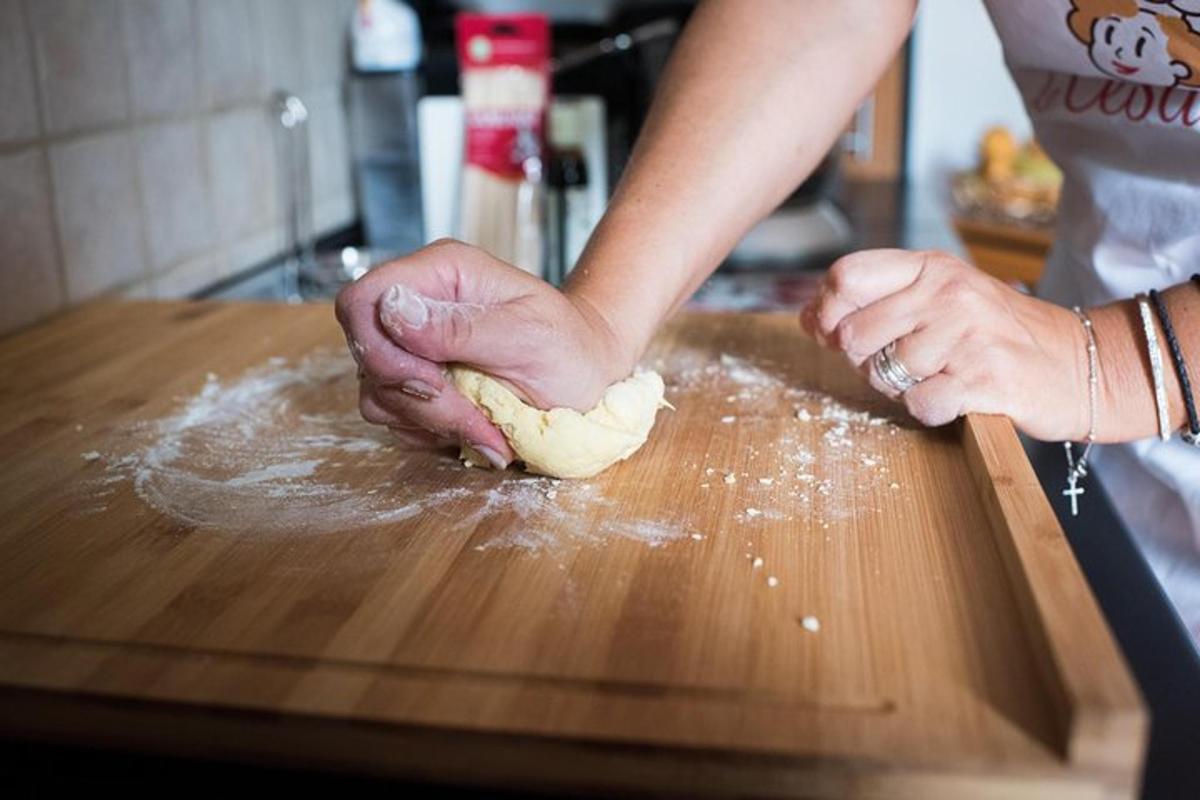 kona að hnoða deig á skurðarbretti