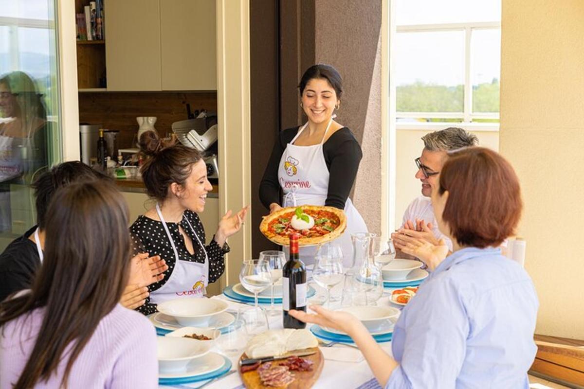 Un grupo de personas sentadas alrededor de una mesa con una pizza.