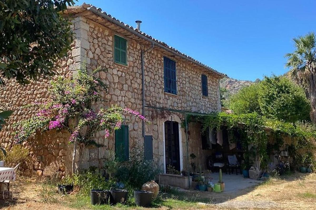 uma velha casa de pedra com persianas verdes e flores