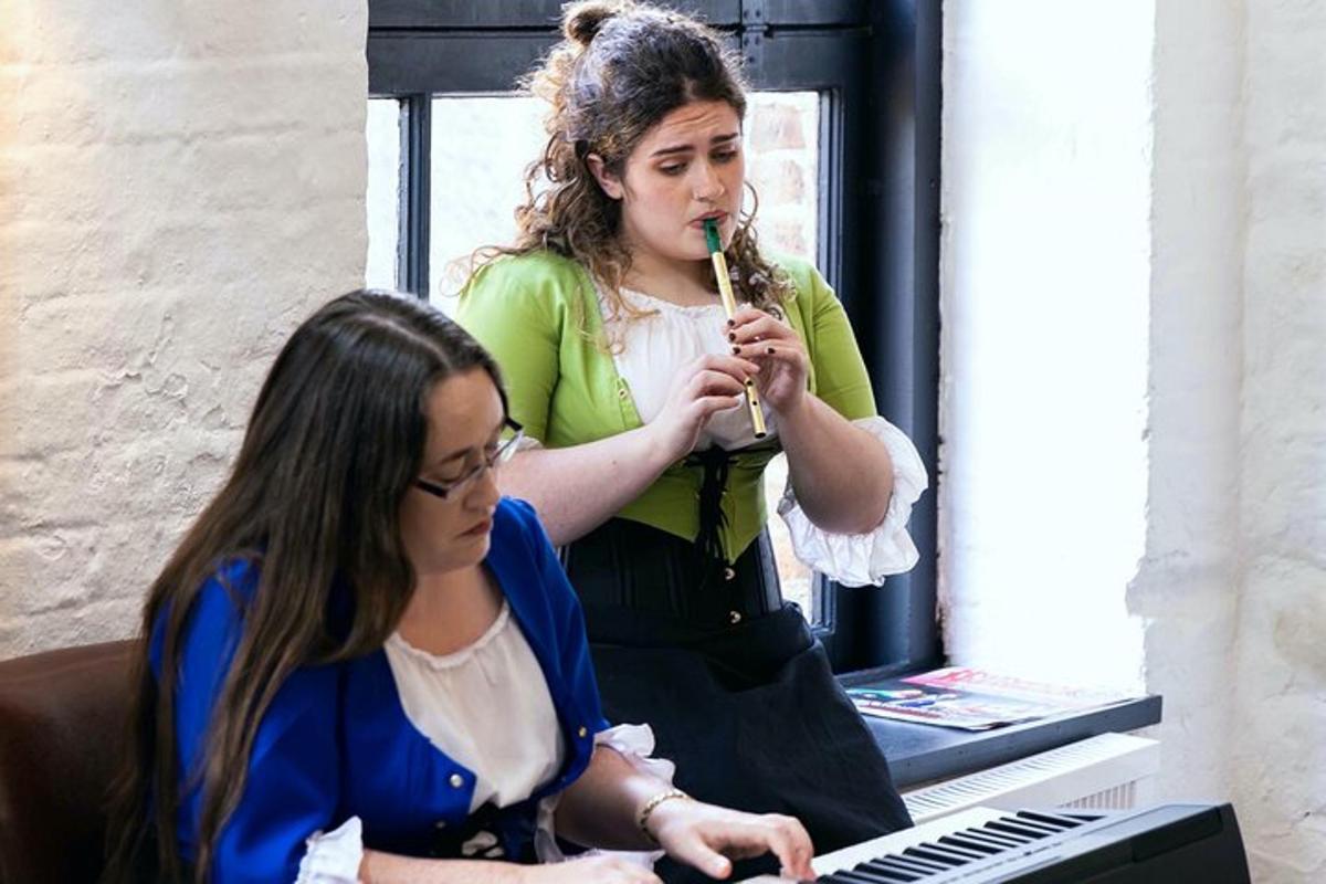 a woman playing a instrument in front of a girl
