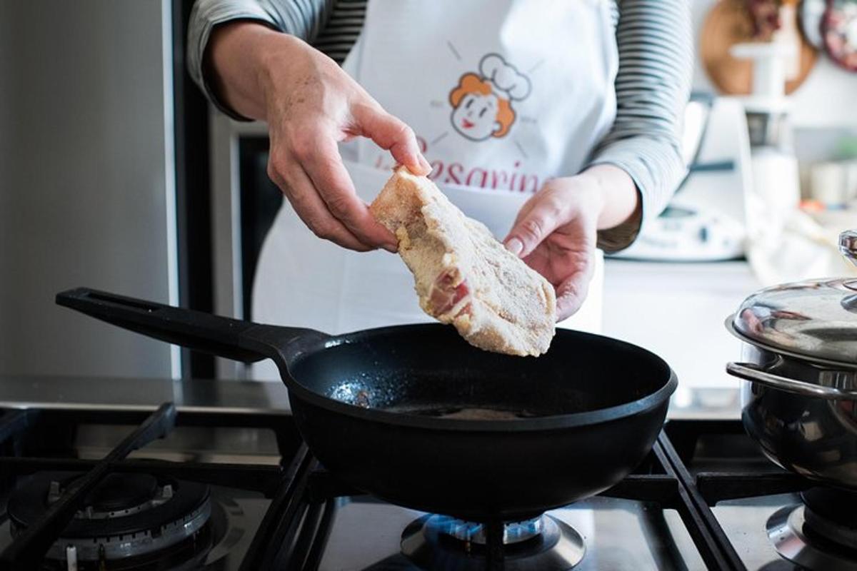 شخص يحمل قطعة خبز يطهى في مقلاة