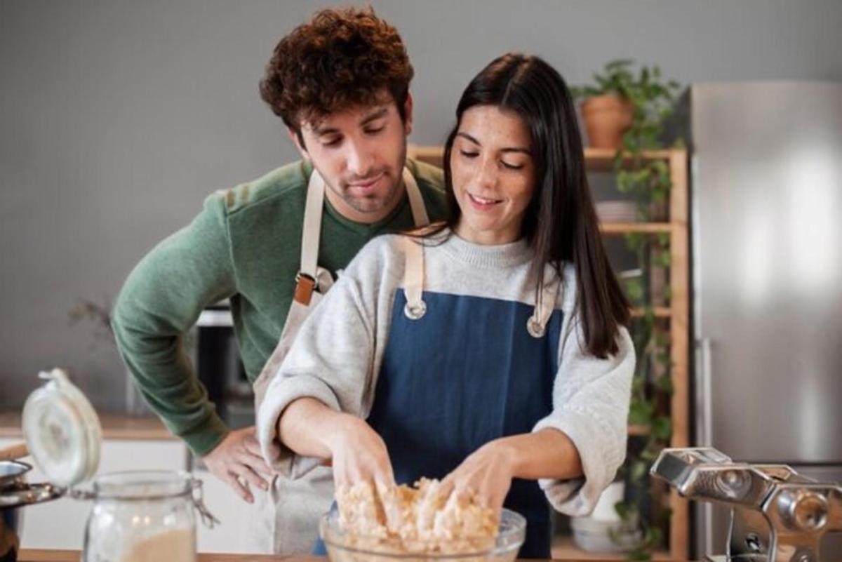Ein Mann und eine Frau stehen in einer Küche und bereiten Essen vor