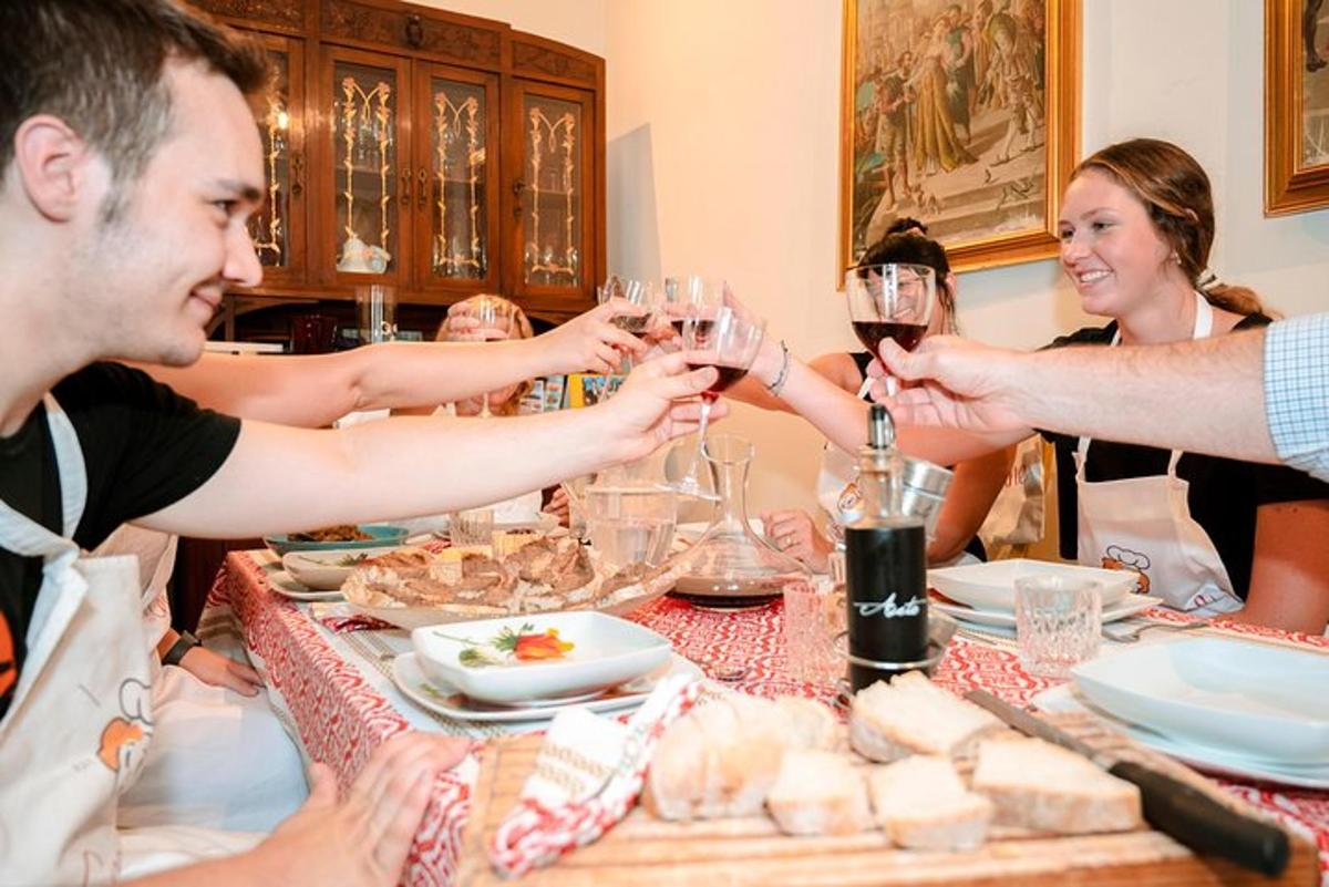 skupina lidí sedících kolem stolu s vinnými sklenicemi