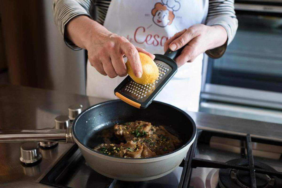 una persona che tiene in mano un limone in una pentola di cibo