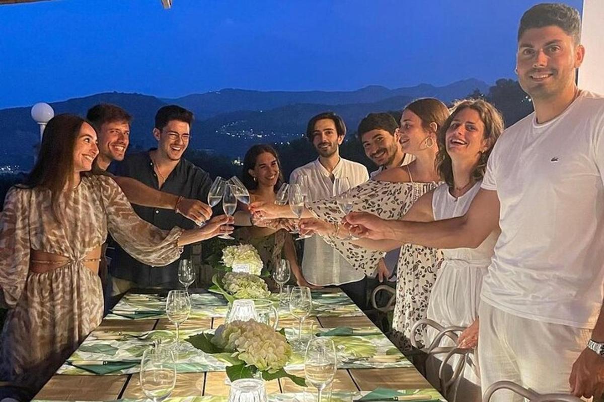 un grup de persones sostenint copes de vi a una taula