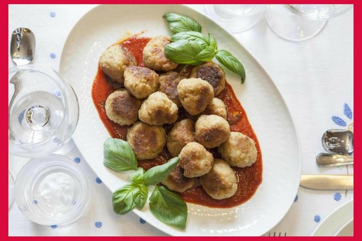 un piatto di cibo con polpette e salsa su un tavolo