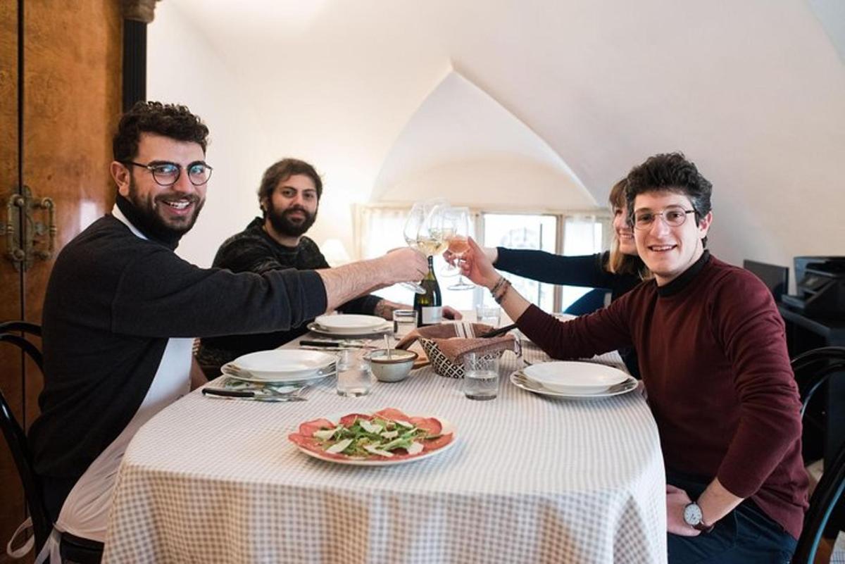 un gruppo di uomini seduti attorno a un tavolo con un bicchiere di vino