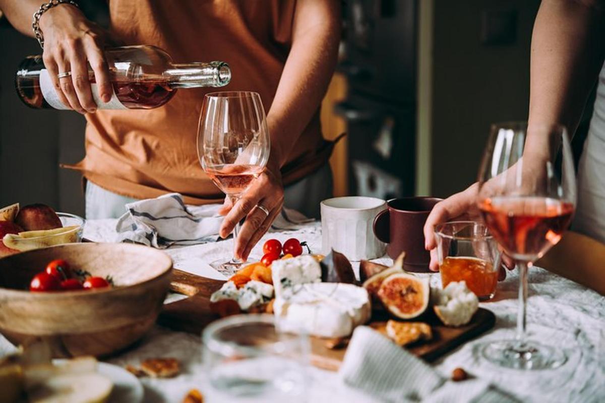 grupp inimesi, kes joovad laua taga veini koos toiduga