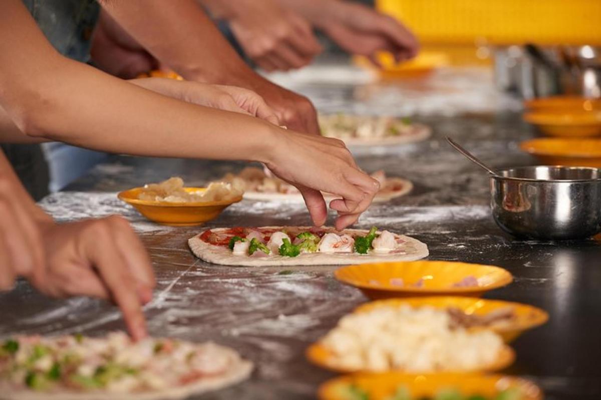 egy csoport ember pizzát készít a pulton