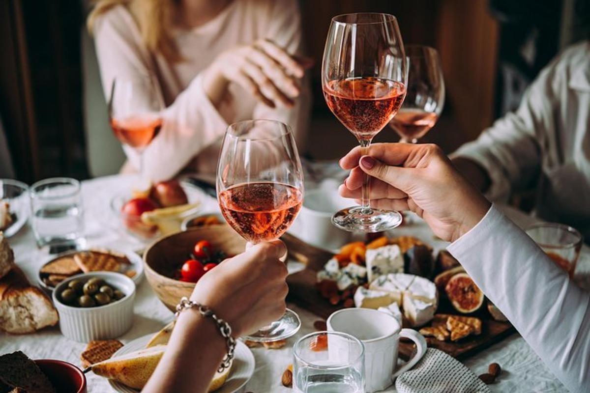 un gruppo di persone sedute attorno a un tavolo che bevono vino