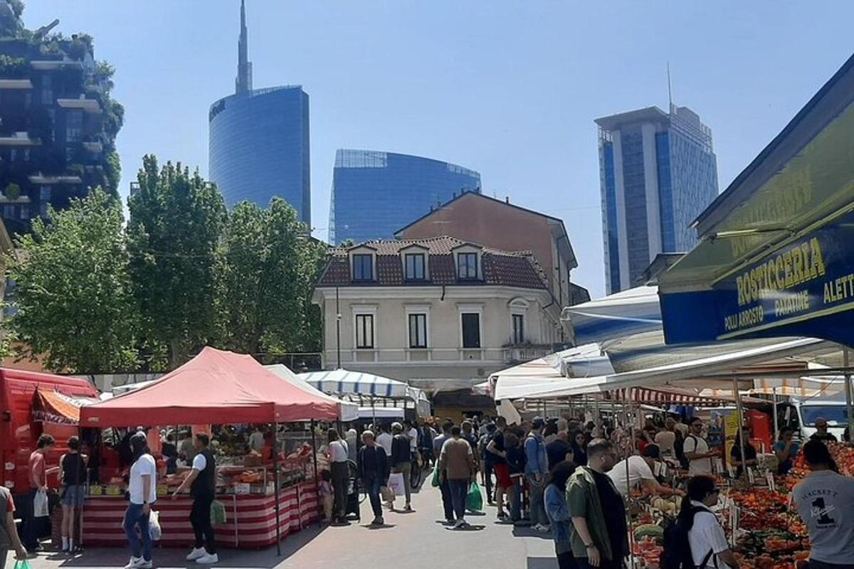 un grup de oameni care se plimbă printr-o piață în aer liber