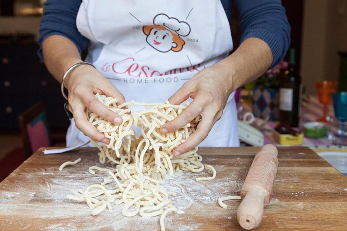 uma pessoa está preparando macarrão em uma tábua de corte