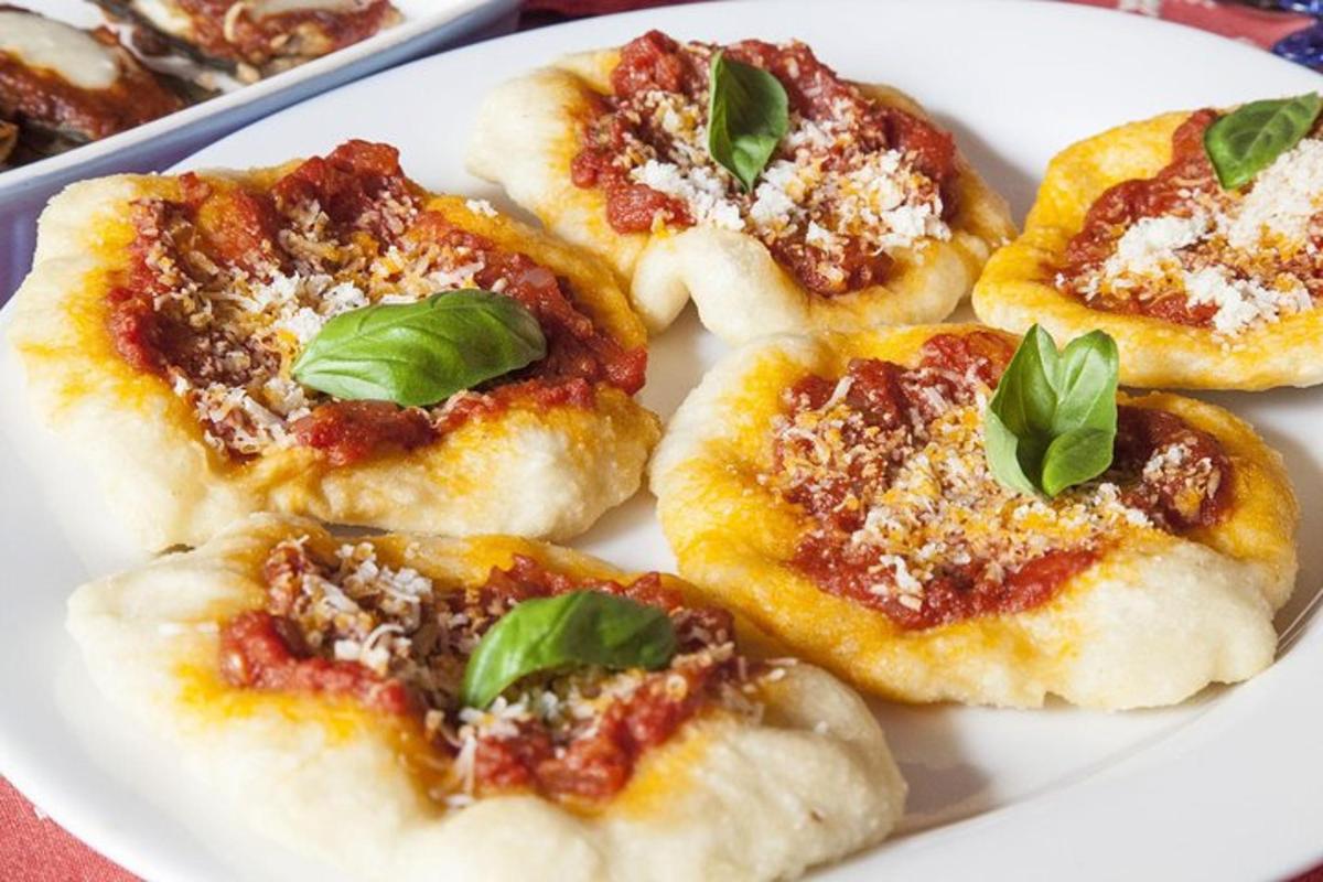 một đĩa pizza nhỏ với húng quế ở trên