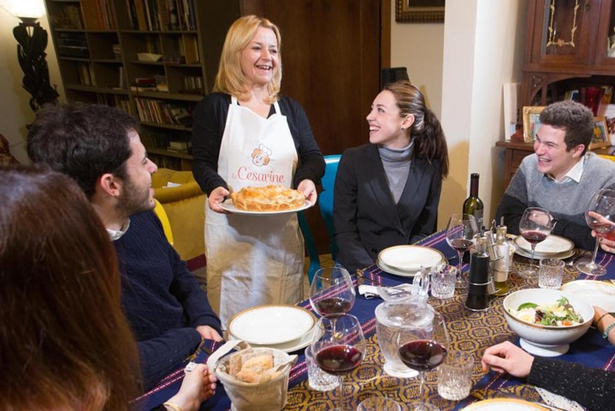 a group of people sitting around a table with a woman holding a plate of food