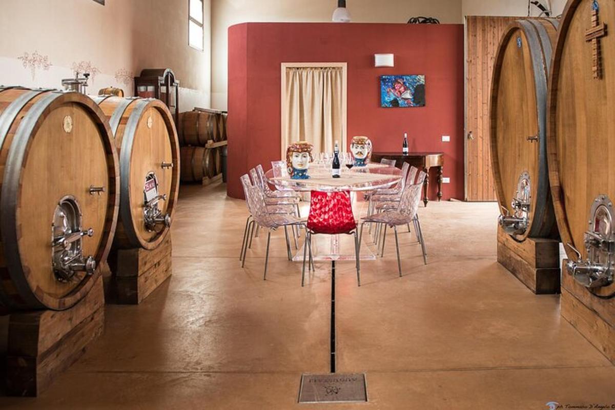 uma mesa e cadeiras em uma sala com barris de vinho