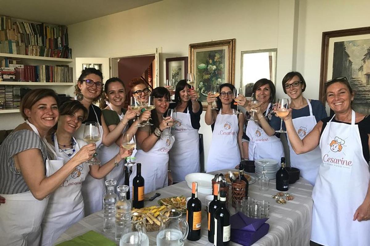 a group of women in aprons holding up wine glasses