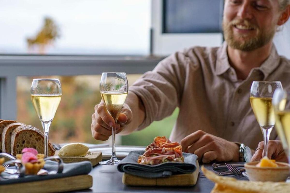 mies istuu pöydässä kahden lasillisen viiniä kanssa