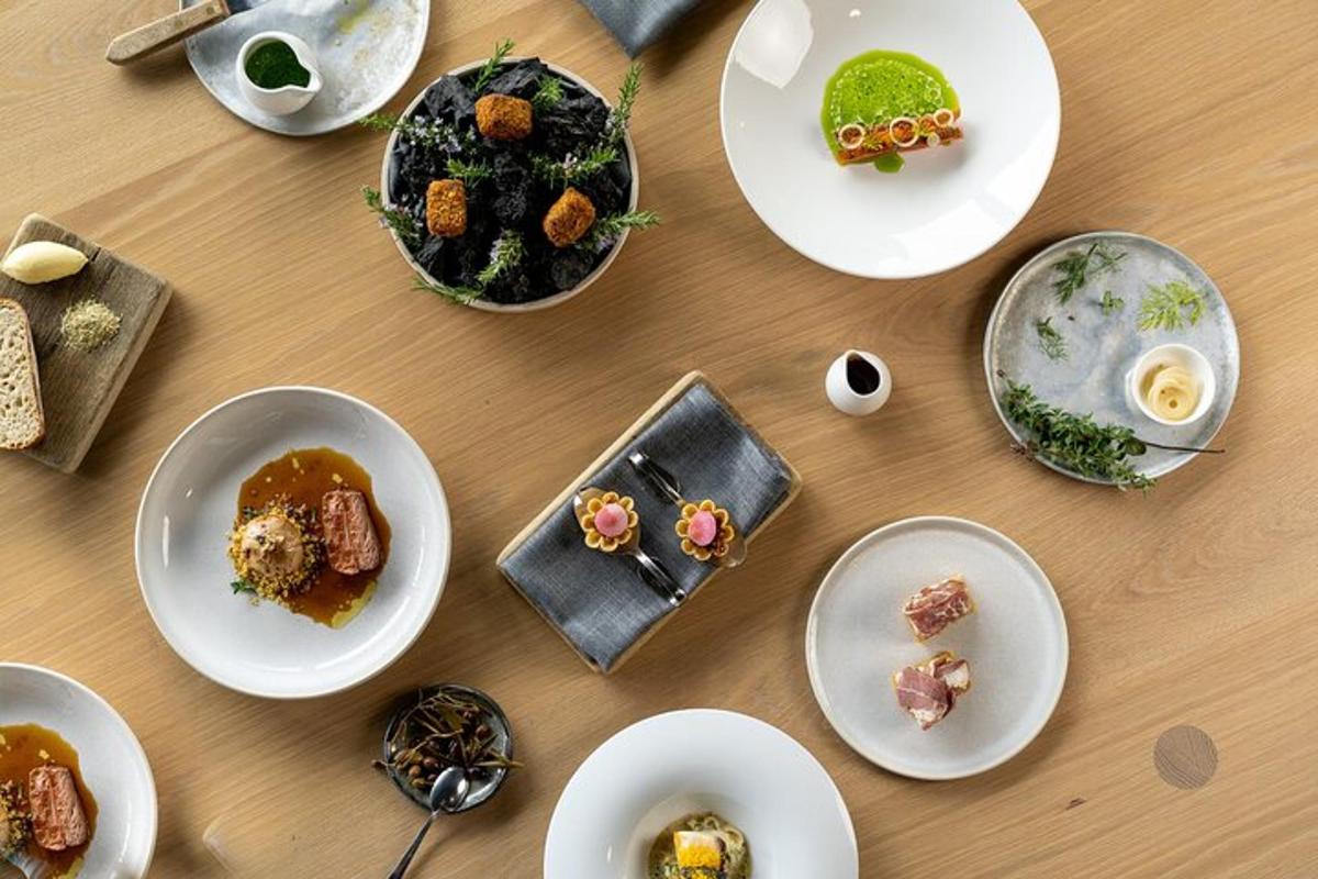 een tafel met witte borden met eten erop