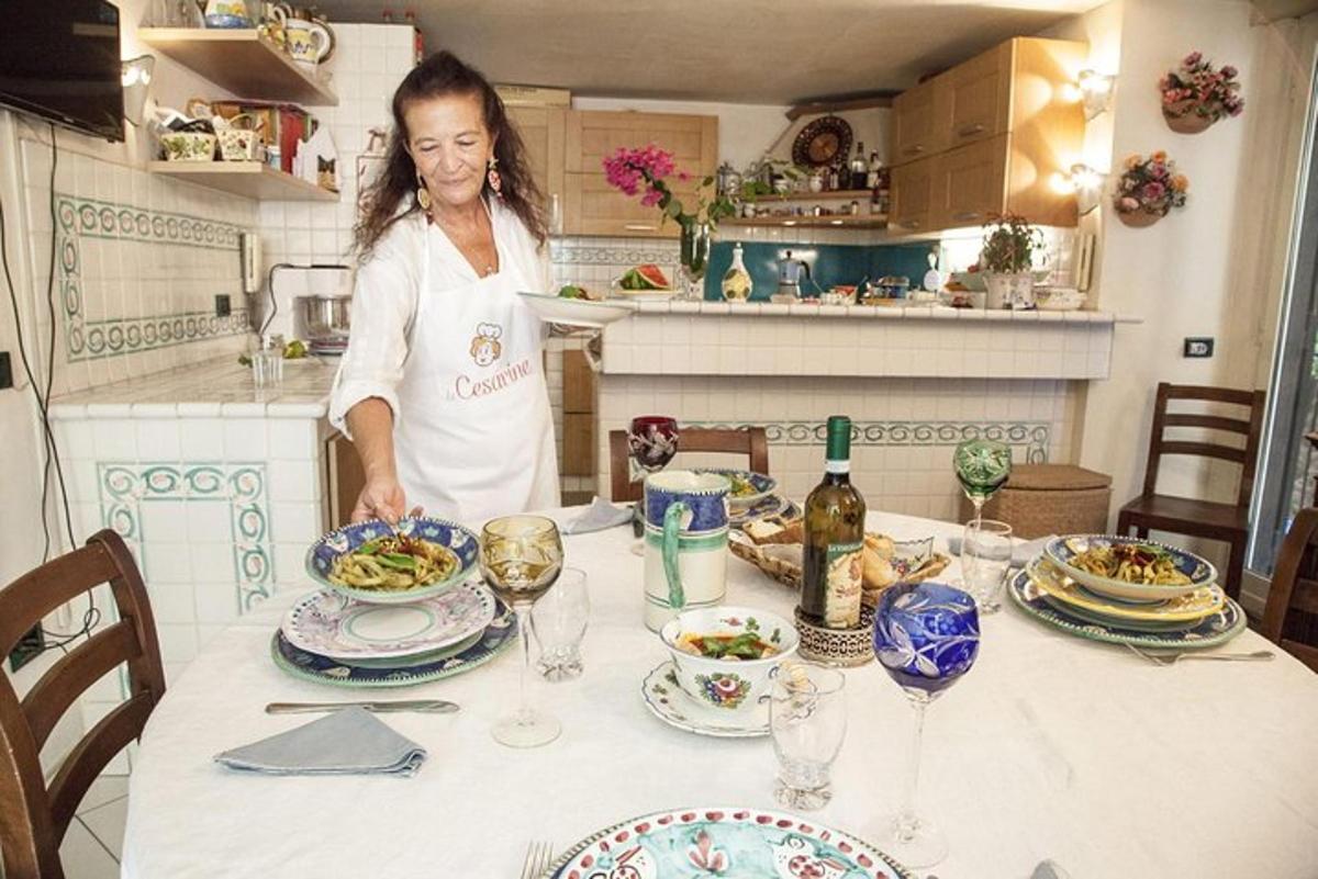 žena stojící v kuchyni se stolem s jídlem
