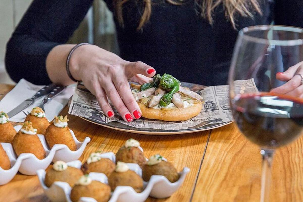 en kvinde, der holder en tallerken med mad og et glas vin