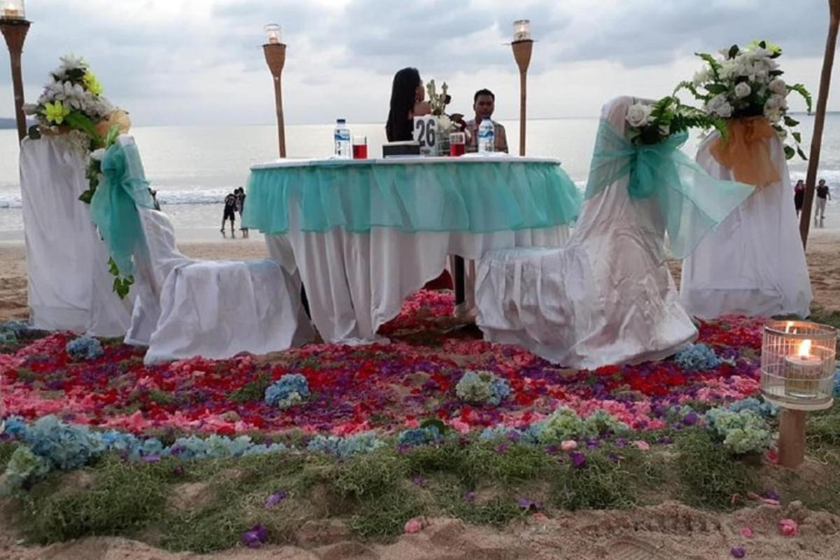 Una mesa en la playa con un ramo de flores.