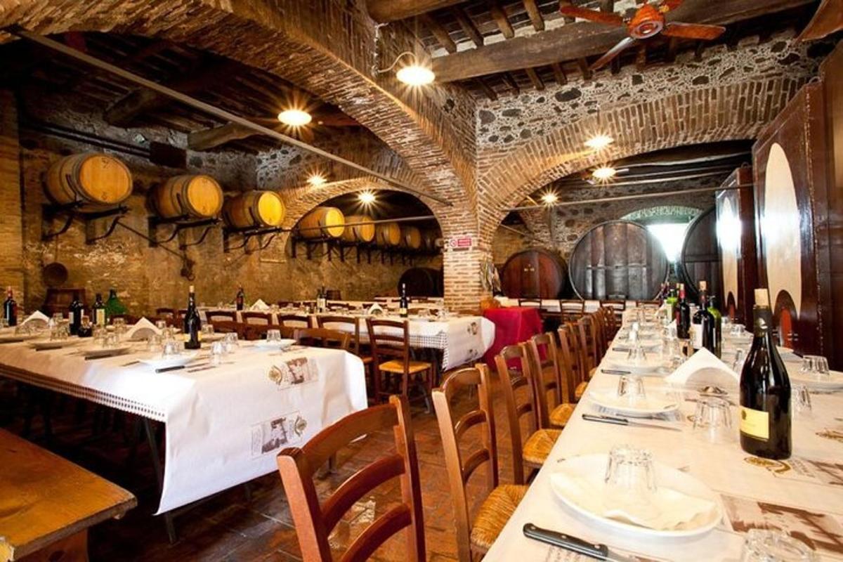 isang restaurant na may mga mesa at upuan at mga barrel ng alak