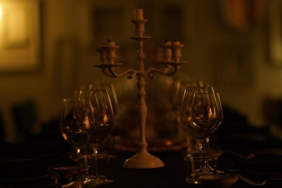 un tavolo con tre bicchieri da vino e un candeliere