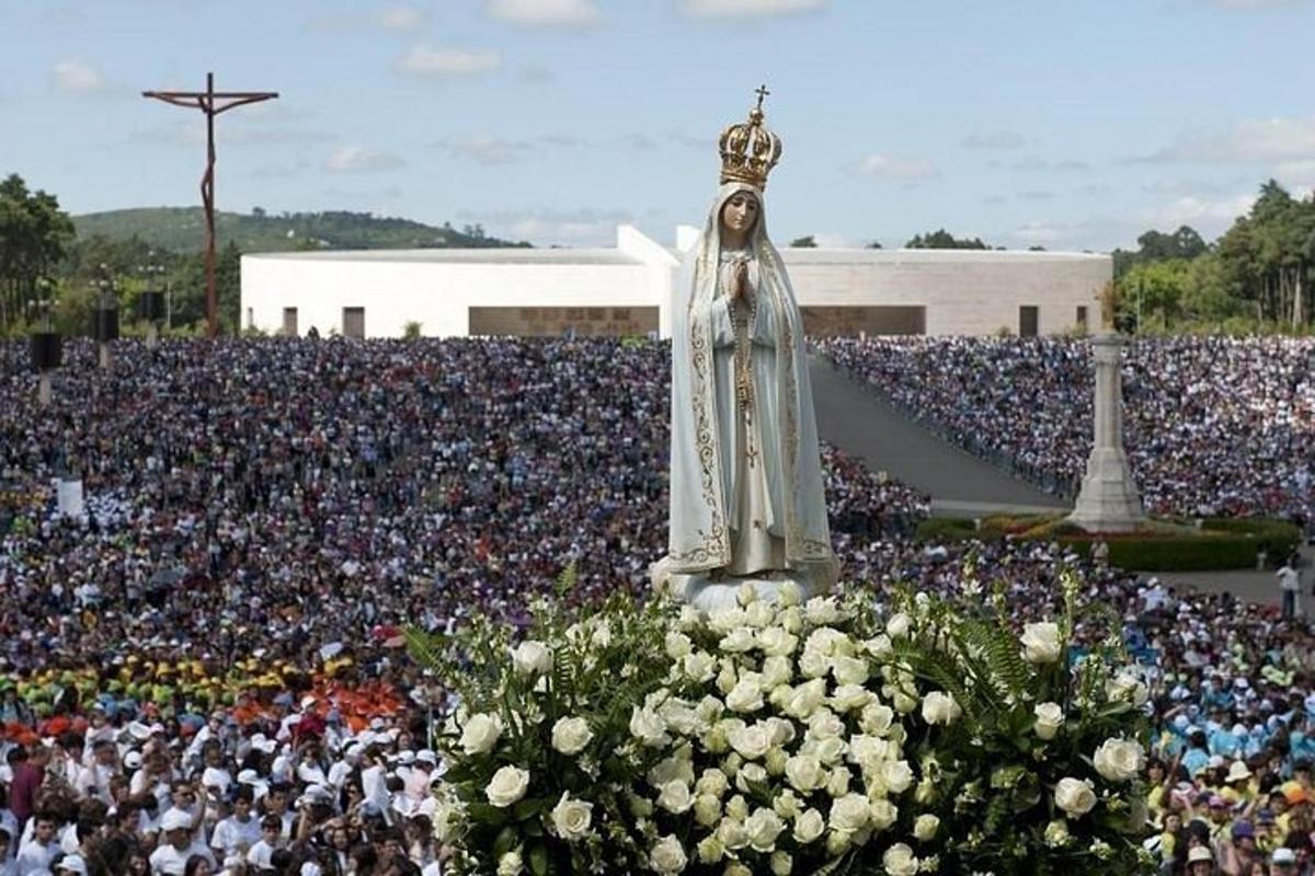 uma grande multidão de pessoas em pé em frente a uma estátua