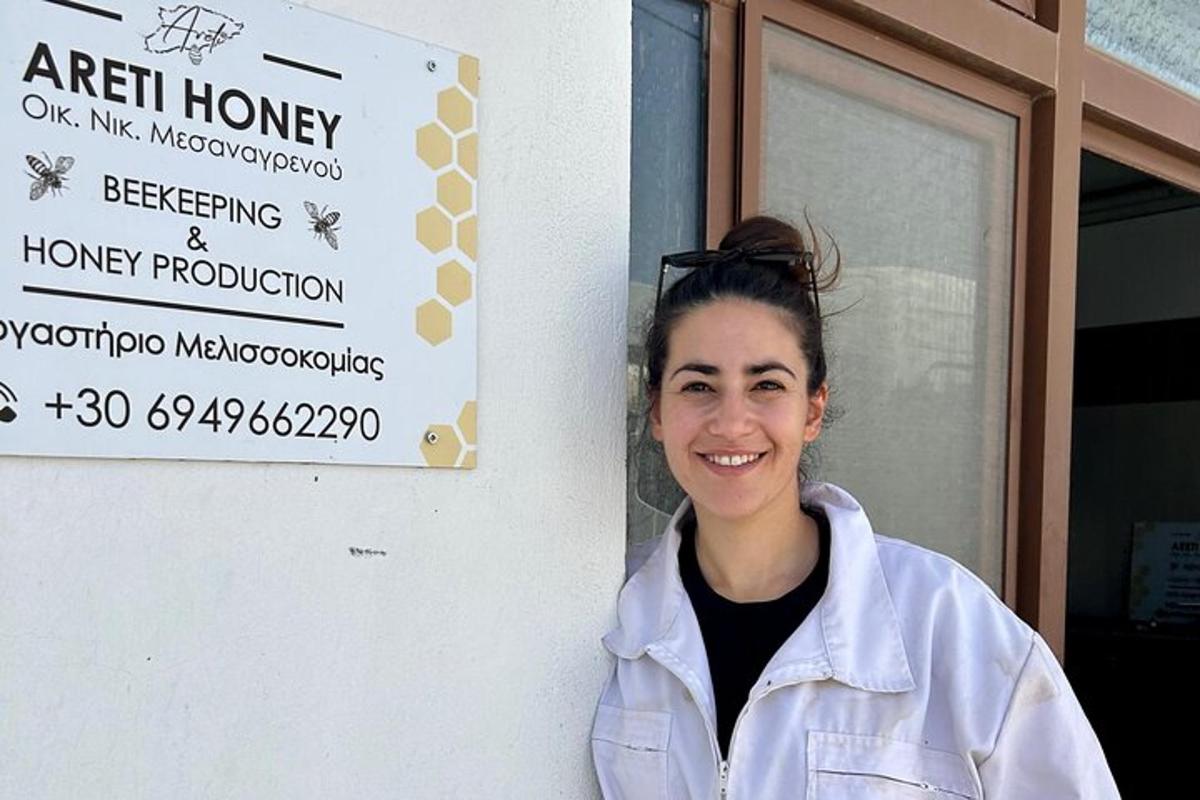 Una mujer está parada frente a un cartel