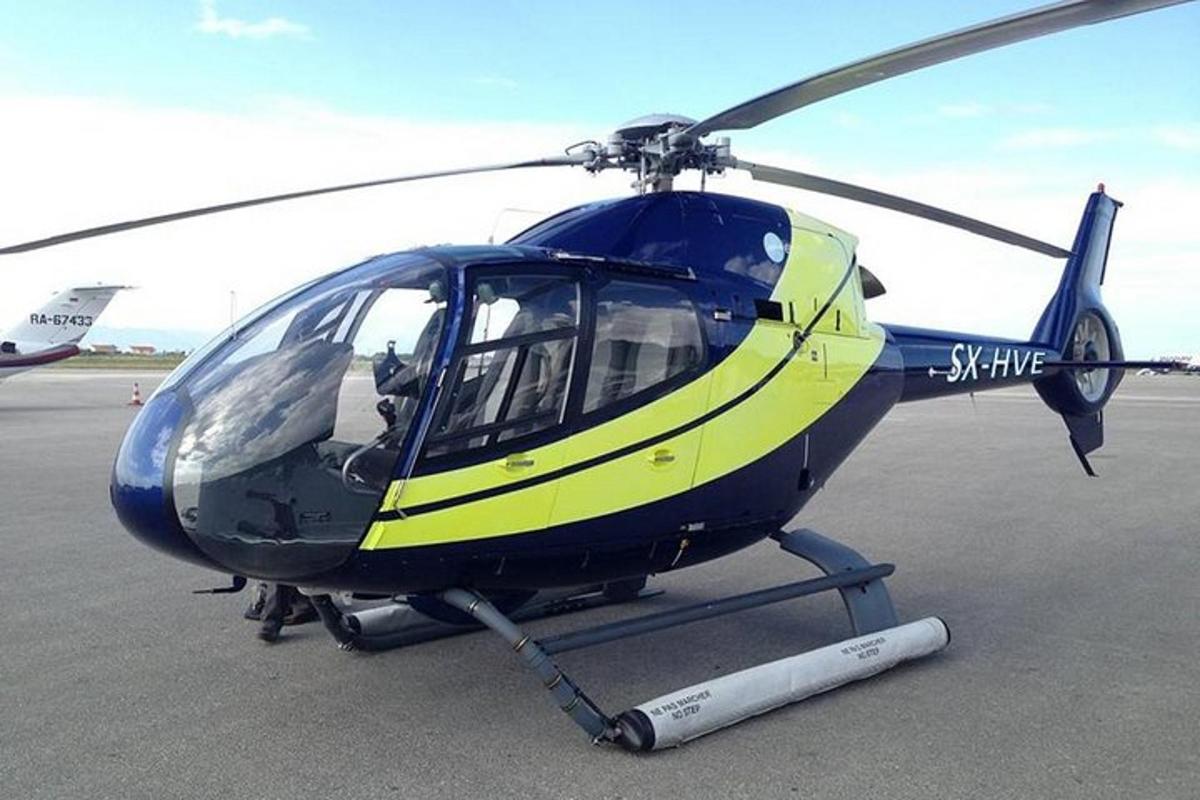 Un helicóptero azul y amarillo estacionado en una pista