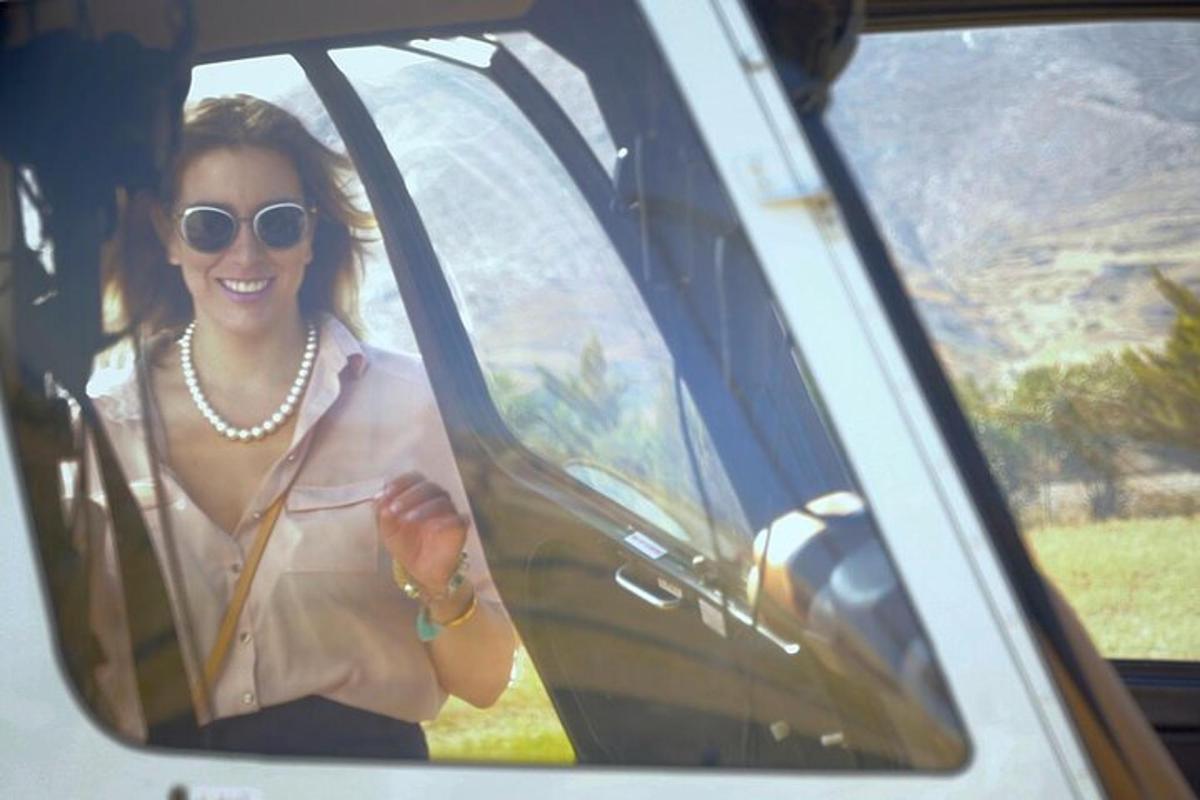 uma mulher está sentada em um carro sorrindo