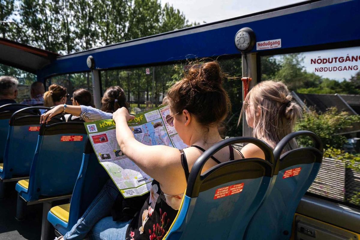 lidé sedící v autobuse a dívající se na mapu