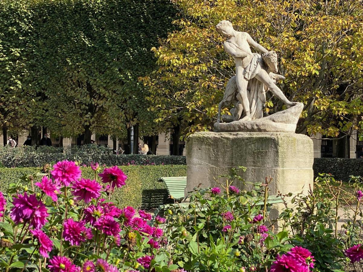 una statua in un parco con fiori rosa