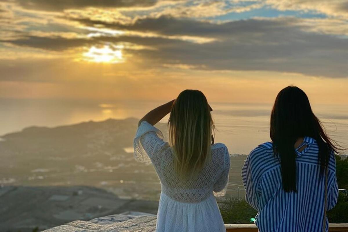 két nő ül egy párkányon és nézi a naplementét