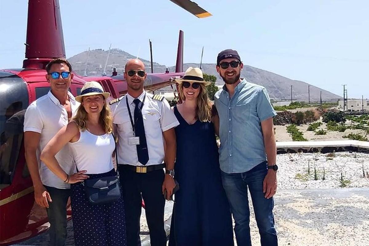 a group of people standing in front of a helicopter