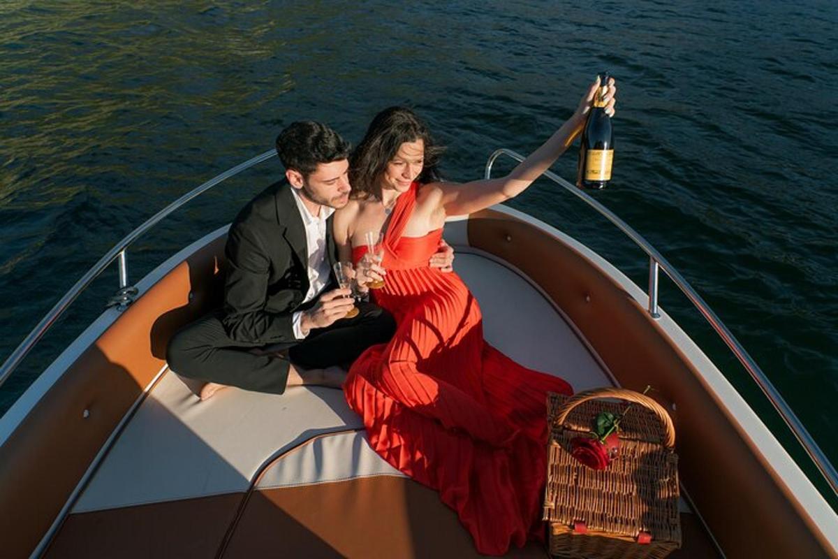 Un hombre y una mujer sentados en un barco sosteniendo bebidas.