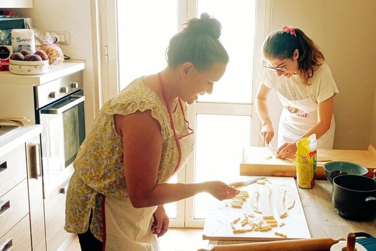 duas mulheres em pé na cozinha preparando comida