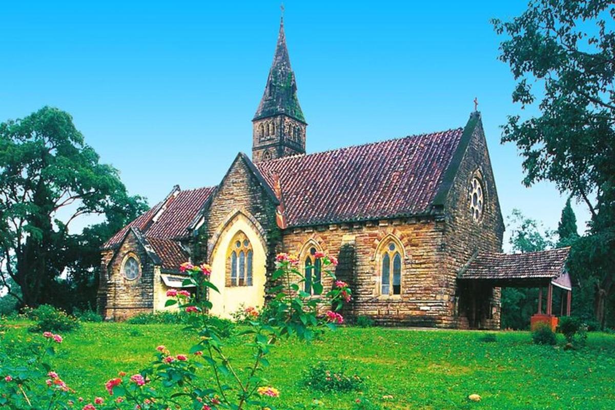 a church with a tower on top of a green field