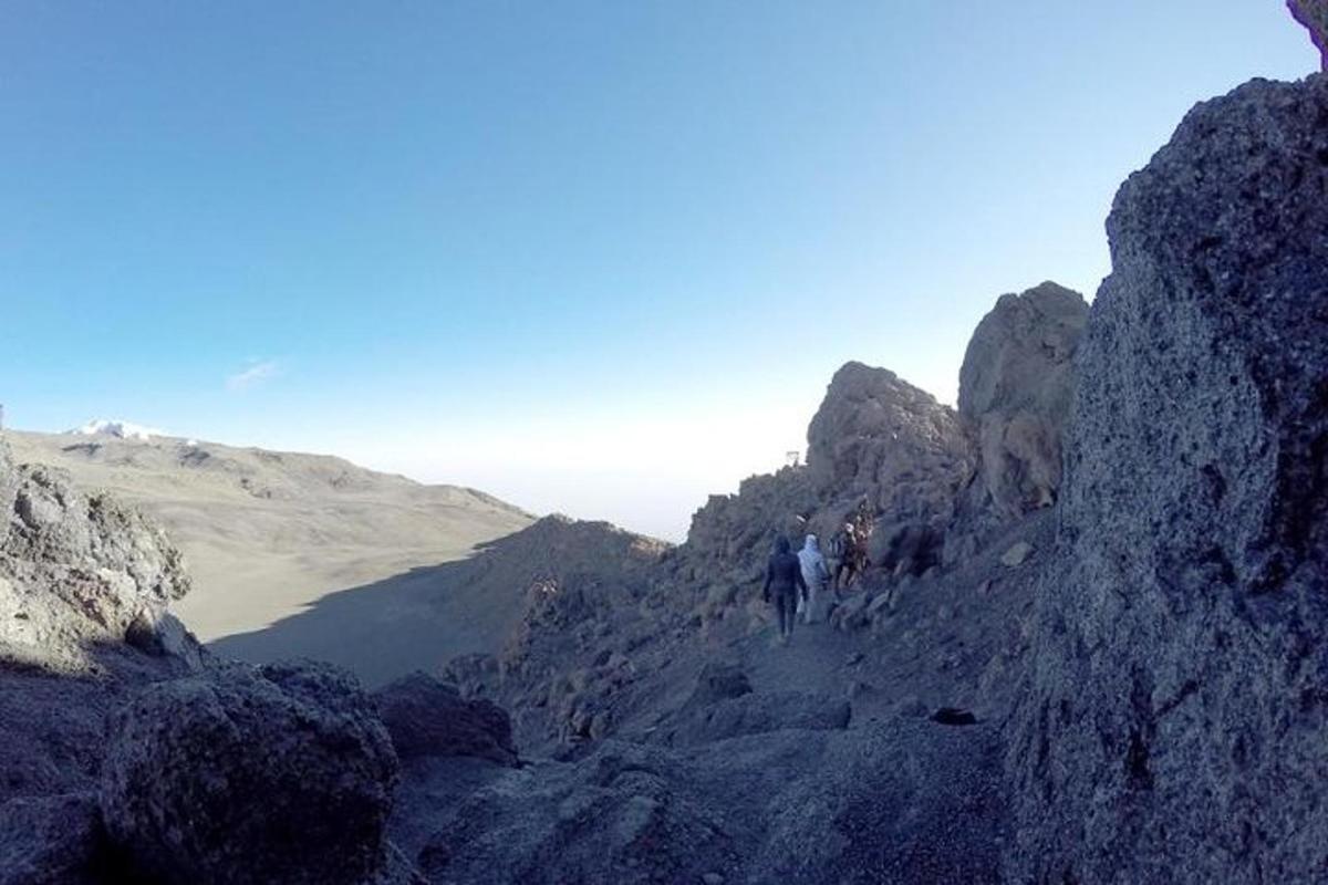 un gruppo di persone che camminano su una montagna rocciosa