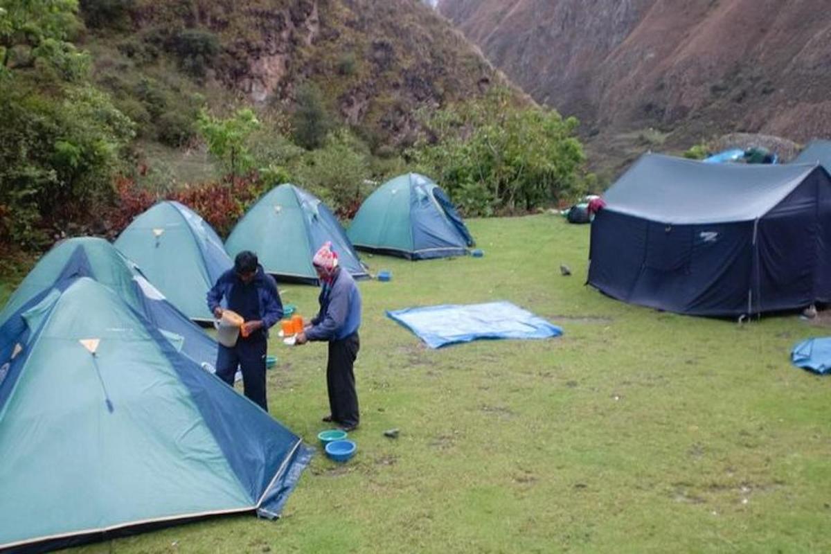 dua orang berdiri di lapangan di samping tenda