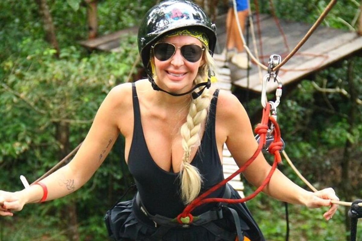 uma mulher de capacete e óculos de sol em uma tirolesa