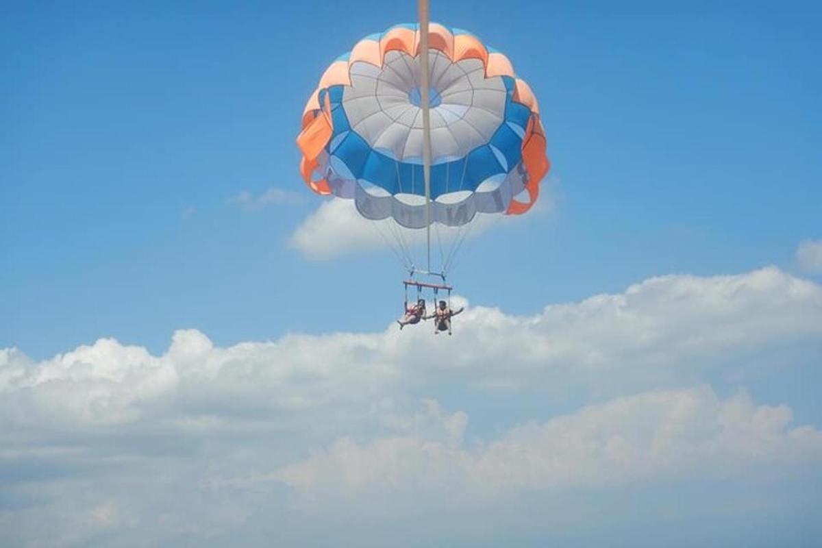 Un paracaídas azul y naranja volando en el cielo.