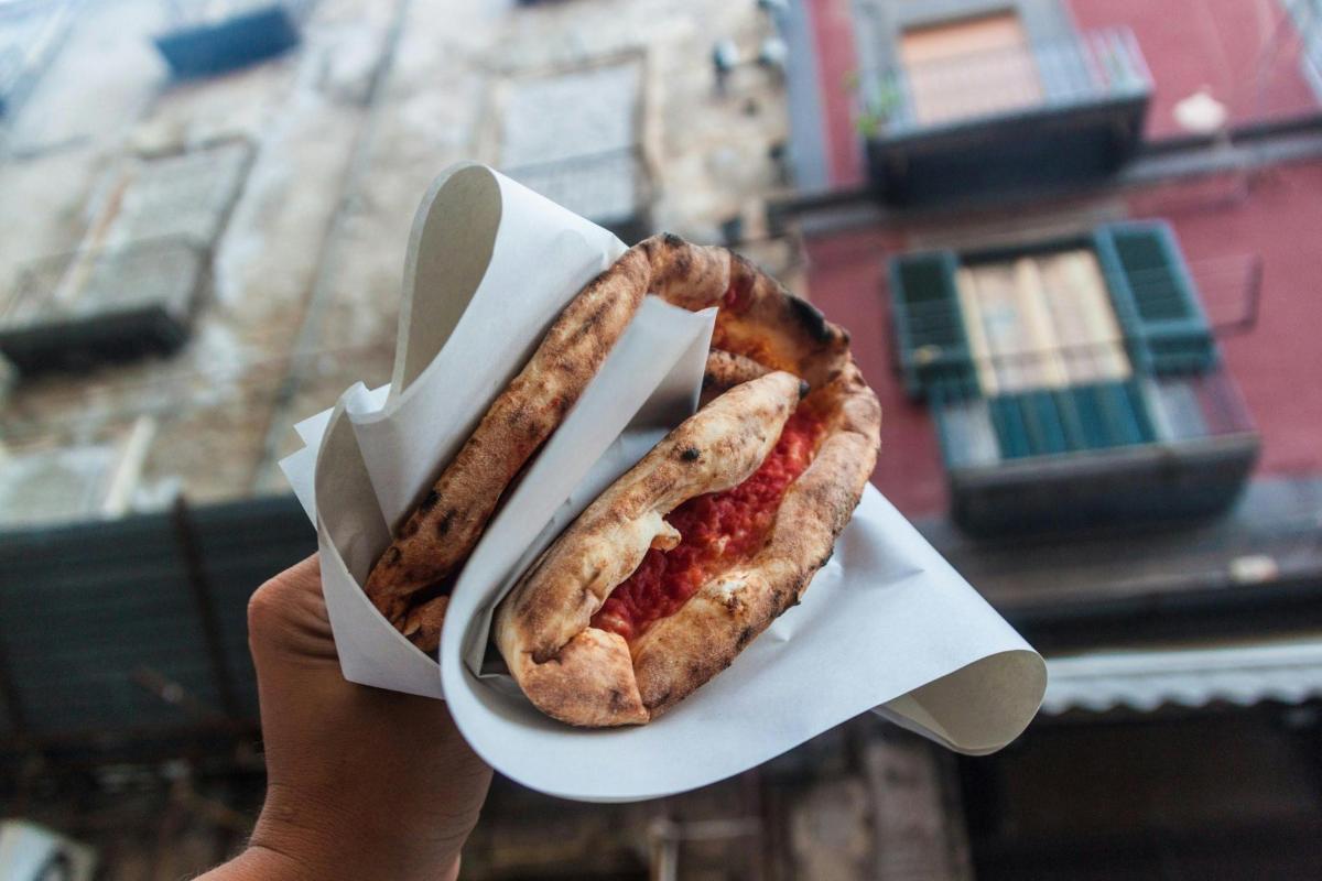 seseorang memegang sandwich di koran